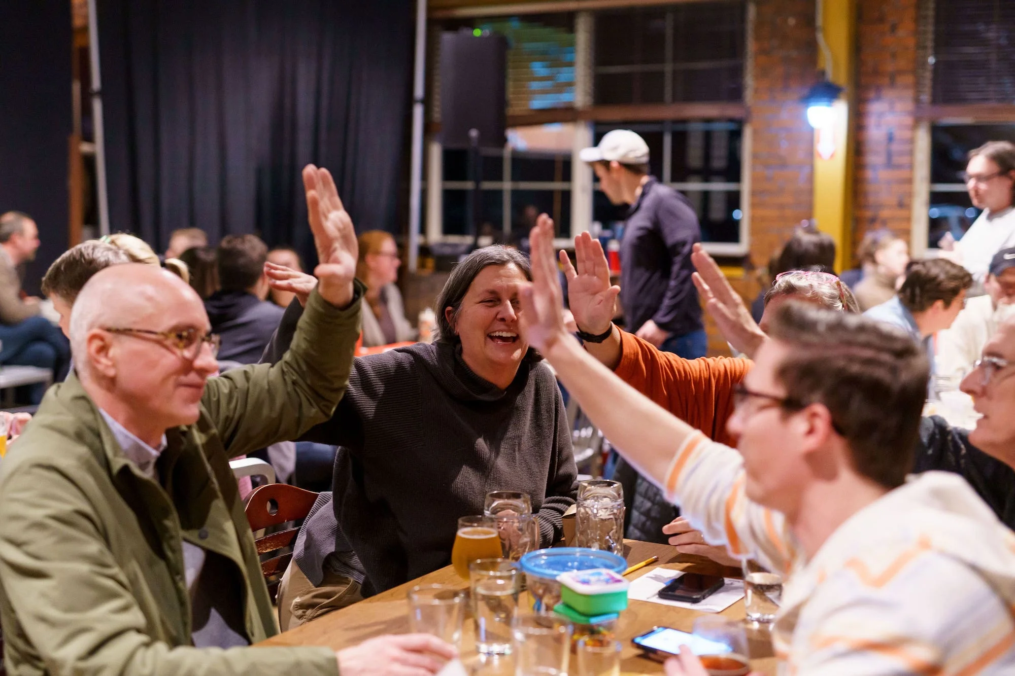 People high-fiving at a Sporcle pub trivia event.